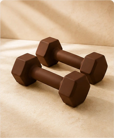 Brown silicone dumbbells photographed on warm stone with soft natural light.