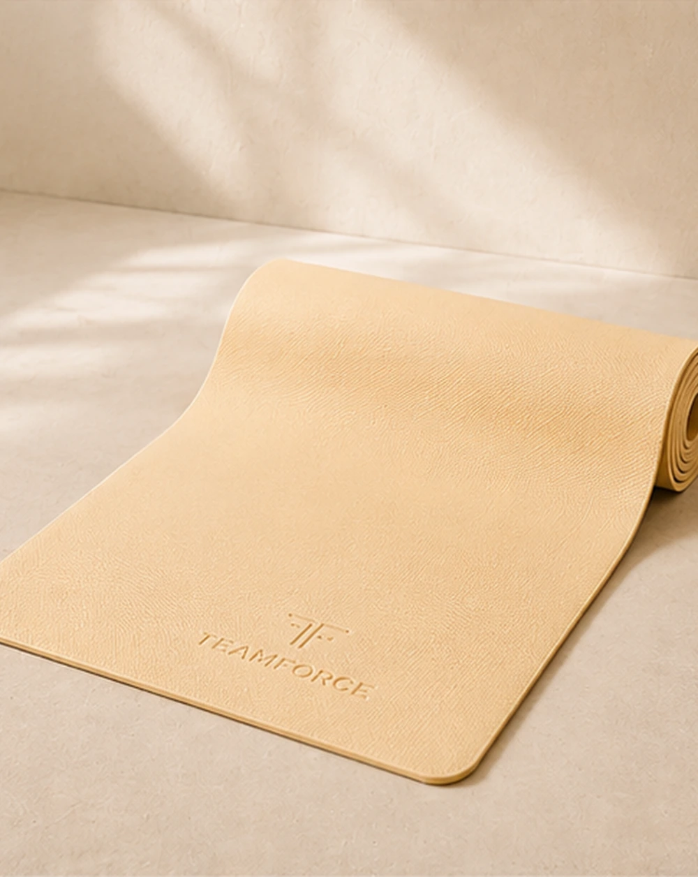 Butter yellow yoga mat rolled out on warm stone with soft sunlight.