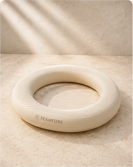 Creamy white Pilates ring photographed on warm stone with soft natural light.